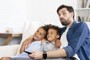 Father watching TV with his kids